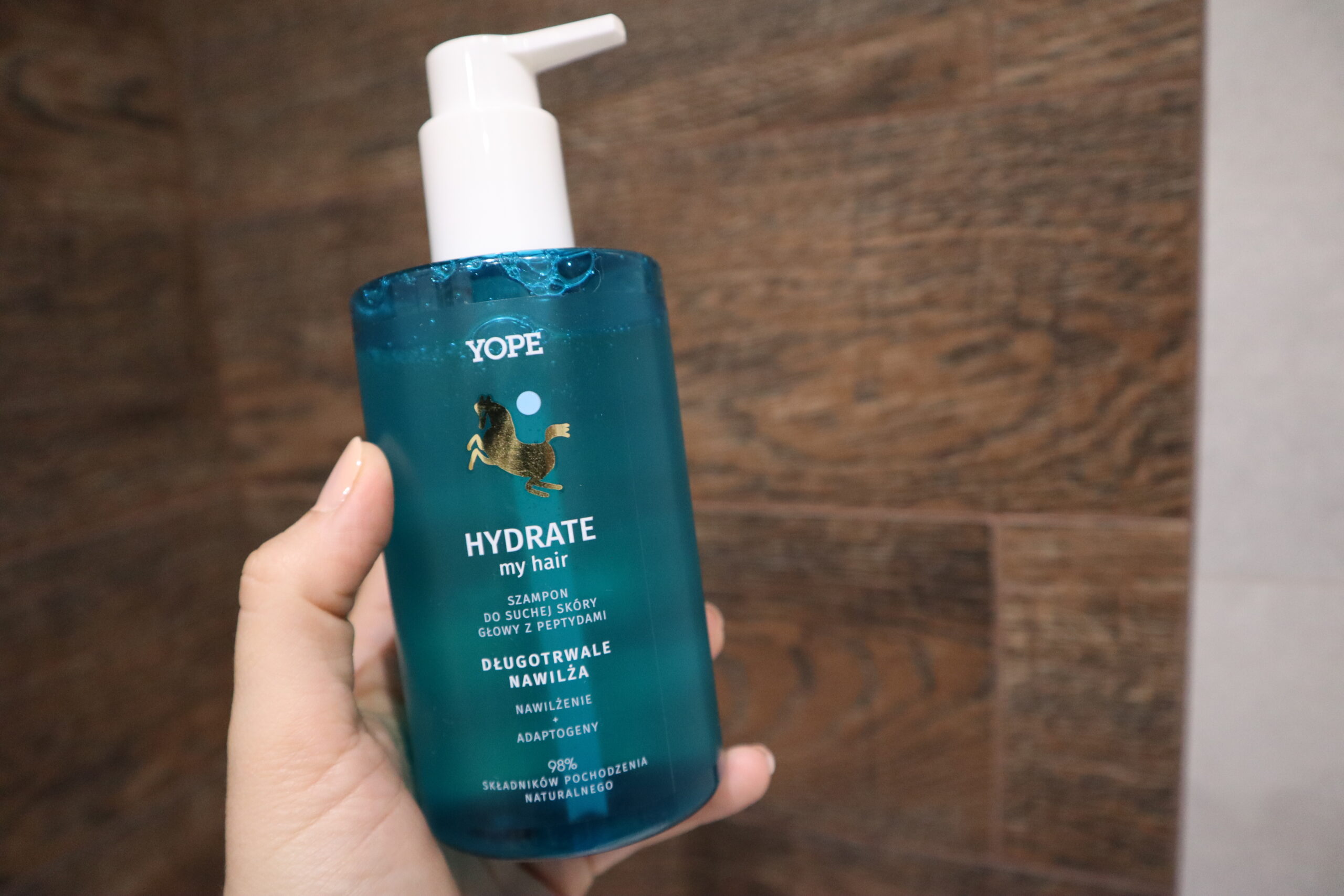 Dłoń trzymająca przy prysznicu szampon nawilżający do włosów Yope Hydrate My Hair