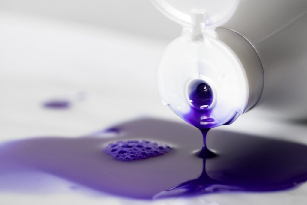 Zbliżenie na tubkę z płynnym, fioletowym szamponem do jasnych włosów