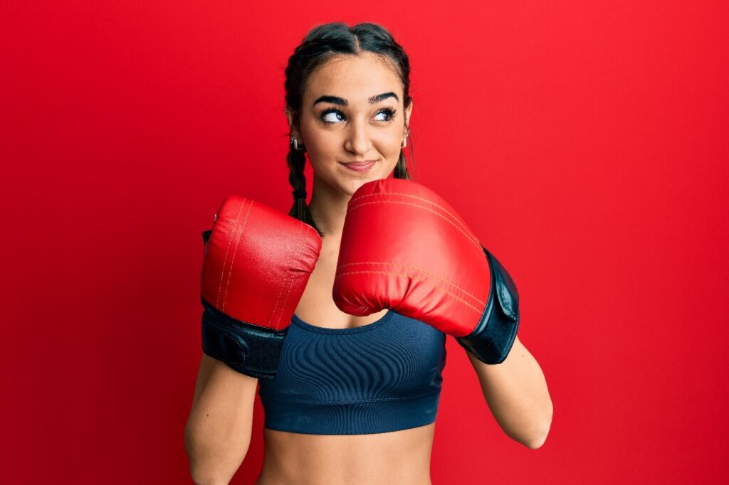 Młoda kobieta w czerwonych rękawicach bokserskich i w warkoczach do walki