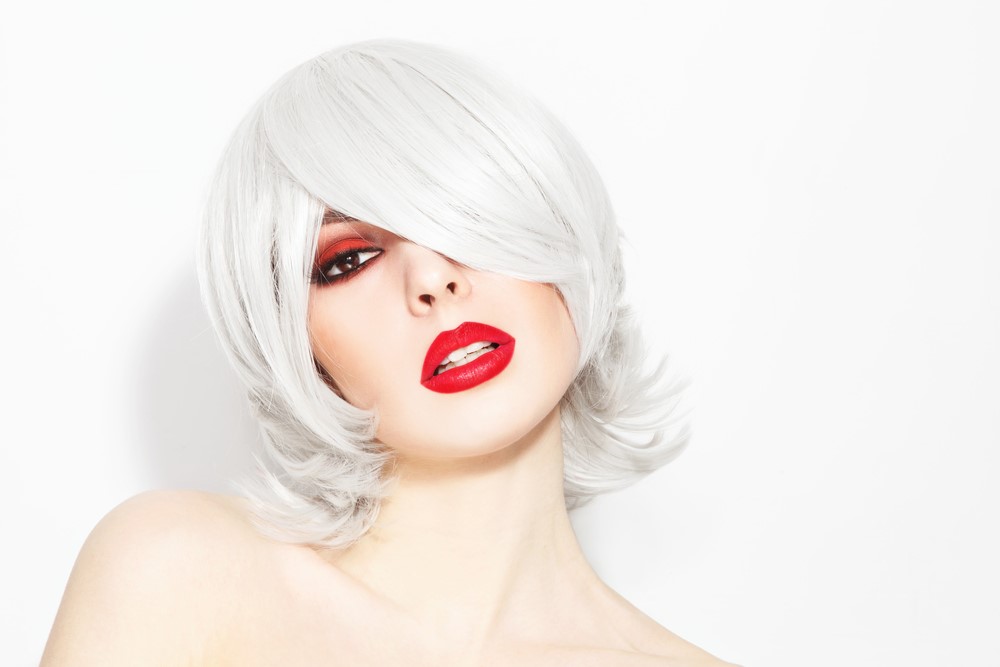 Kobieta w czerwonym makijażu i platynowymi włosami w stylu choppy lob