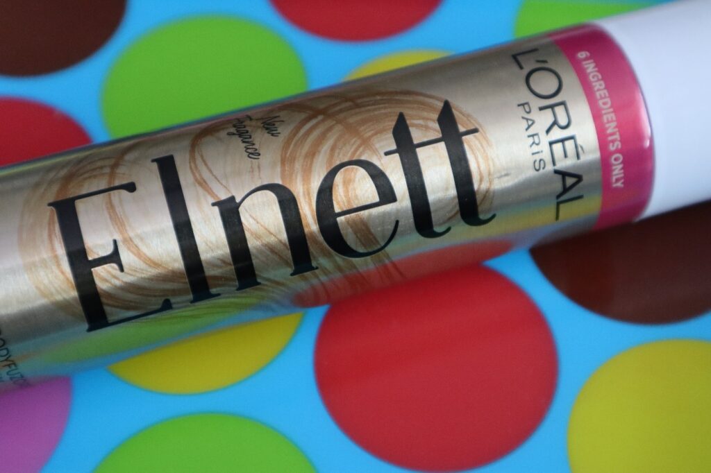 L'Oréal Paris Elnett Satin lakier do włosów bez silikonów na kolorowym tle