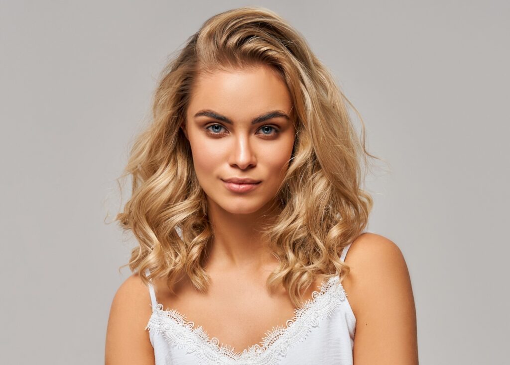 Kobieta z farbowanymi włosami w kolorze miodowy blond (honey blonde)