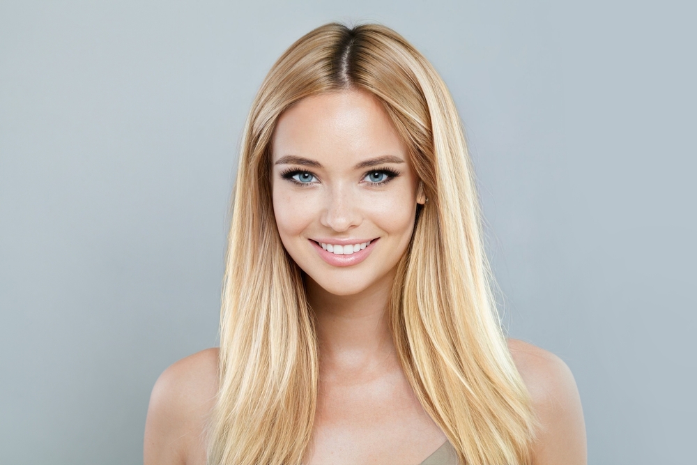 Uśmiechnięta blondynka z długimi, gładkimi włosami