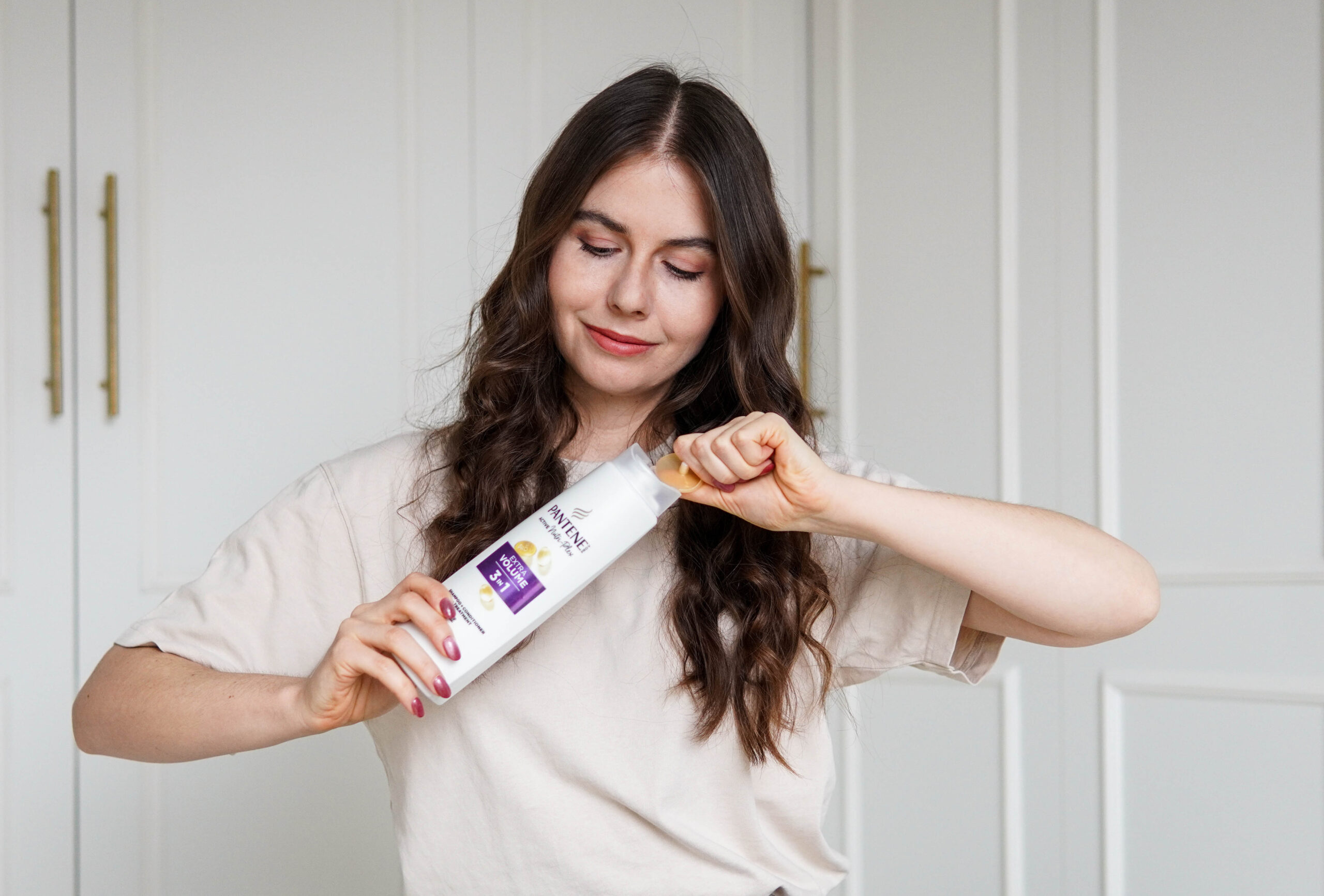 Kobieta trzymająca szampon dodający objętości Pantene Pro-V Extra Volume