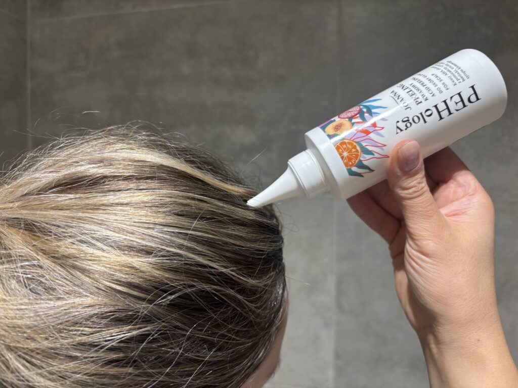 kobieta aplikująca peeling kwasowy Joanna PEHology na skórę głowy