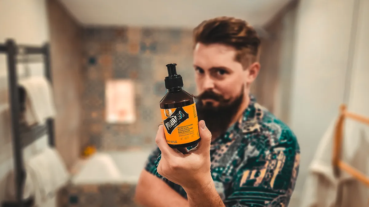 Mężczyzna trzymający szampon do brody Proraso Wood and Spice