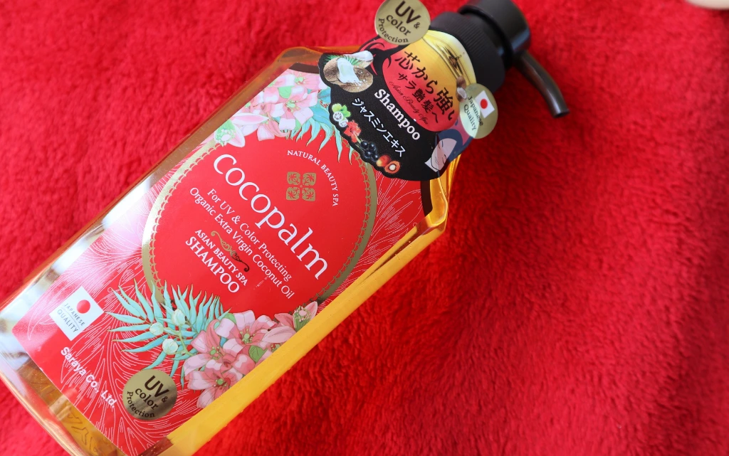 Nabłyszczający szampon do włosów Cocopalm na tle czerwonego kocyka 