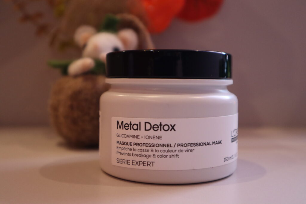 Opakowanie maski Metal Detox do włosów po zabiegu farbowania na tle jesiennych dekoracji