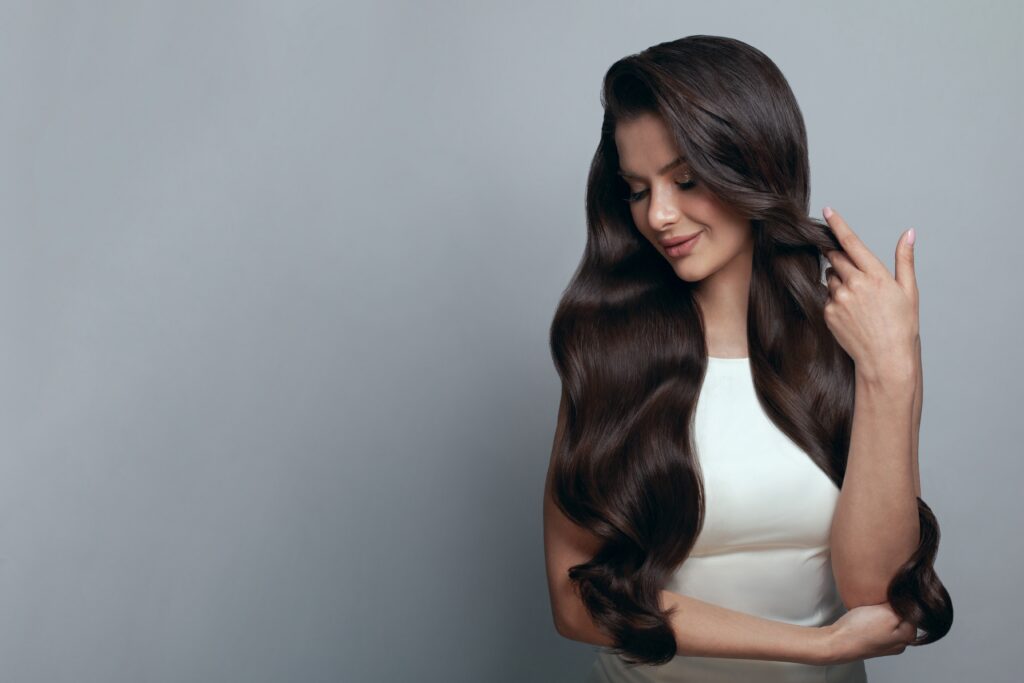 Portret pięknej kobiety z długimi, błyszczącymi ciemnymi włosami
