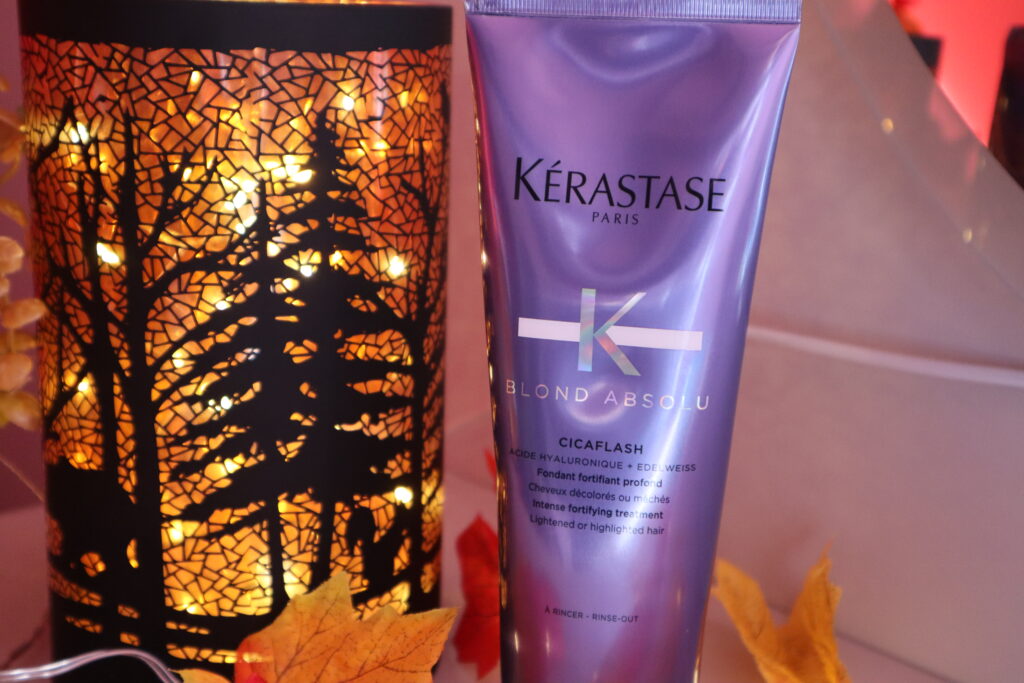 Odżywka do włosów Kerastase Blond Absolu Cicaflash obok jesiennej lampki dekoracyjnej