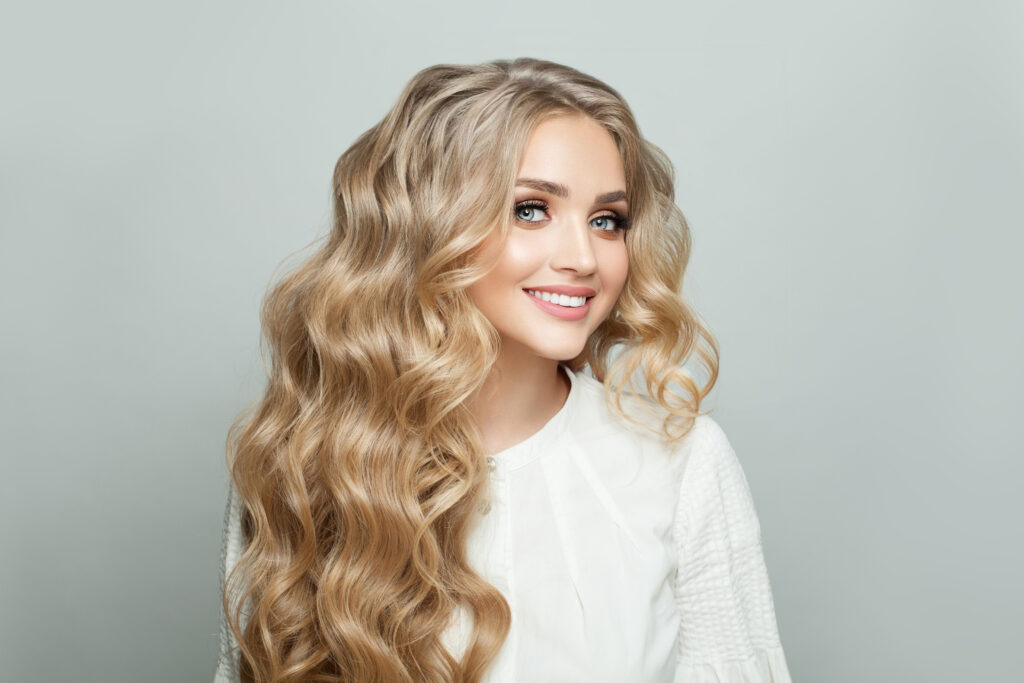 Uśmiechnięta blondynka z długimi blond włosami i z jasną karnacją