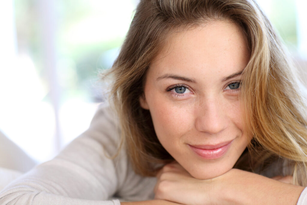 Uśmiechnięta blondynka z jasnymi włosami i niebieskimi oczami
