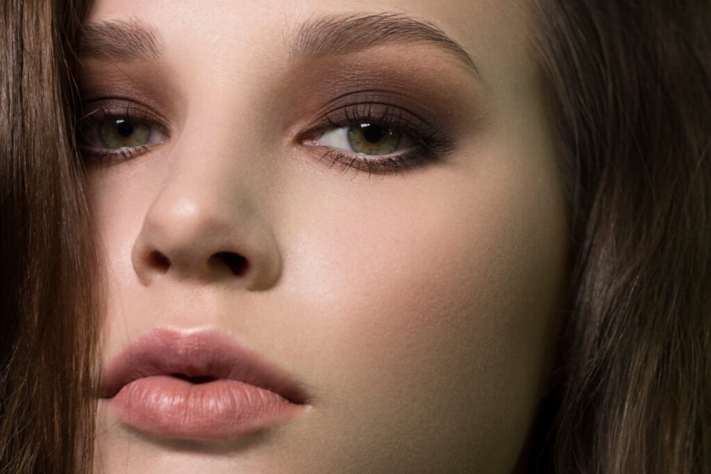 Portret młodej kobiety z zielonymi oczami i brązowymi włosami