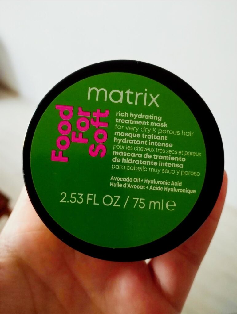 Kobieca dłoń trzymająca opakowanie maski do włosów Matrix Food for soft
