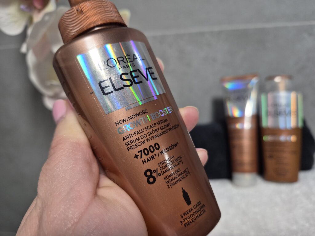 Opakowanie szamponuprzeciw wypadaniu włosów L’Oreal Paris Elseve Growth Booster w kobiecej dłoni
