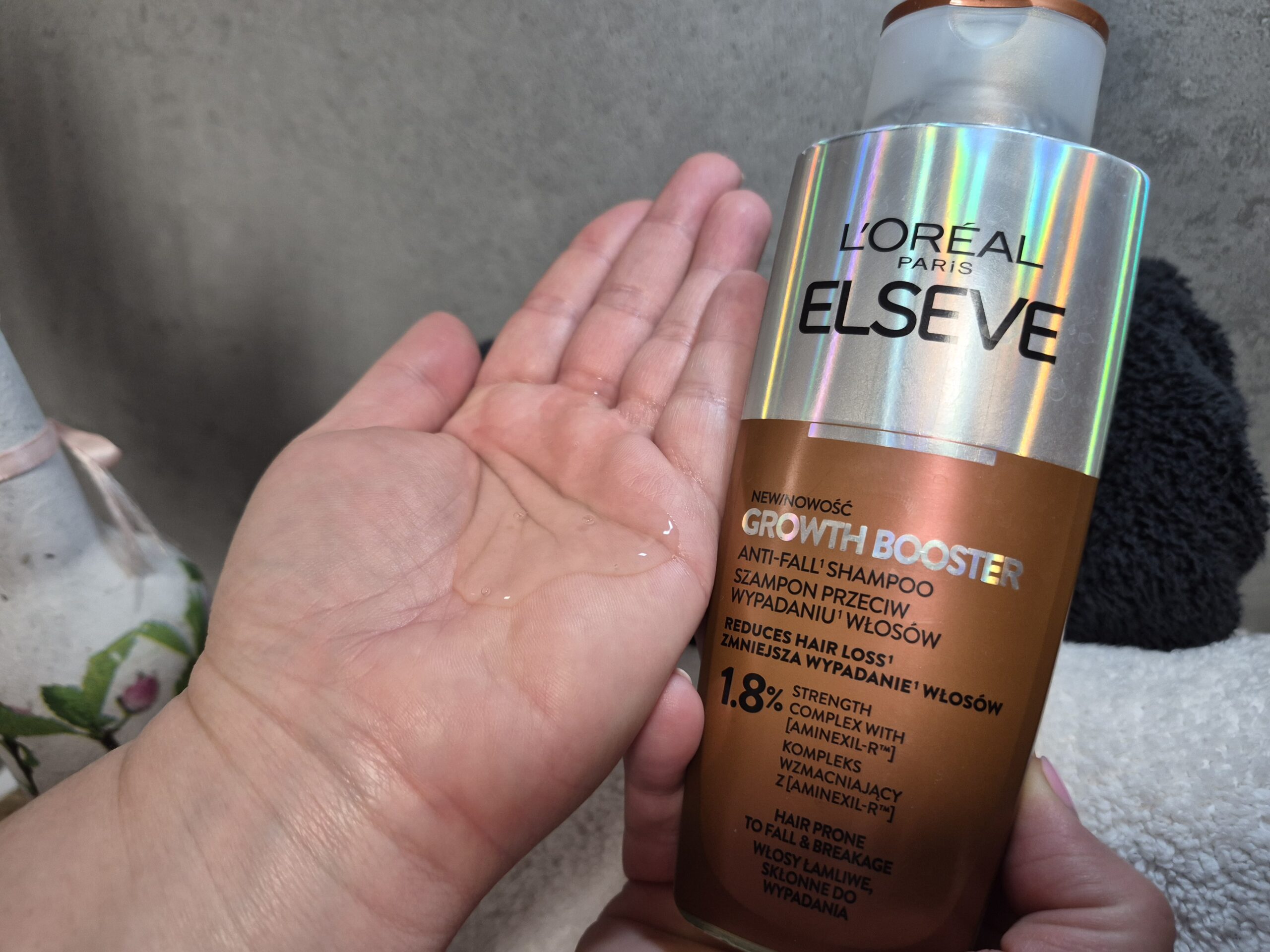Otwarta kobica dłoń, na niej szampon L’Oreal Paris Elseve Growth Booster