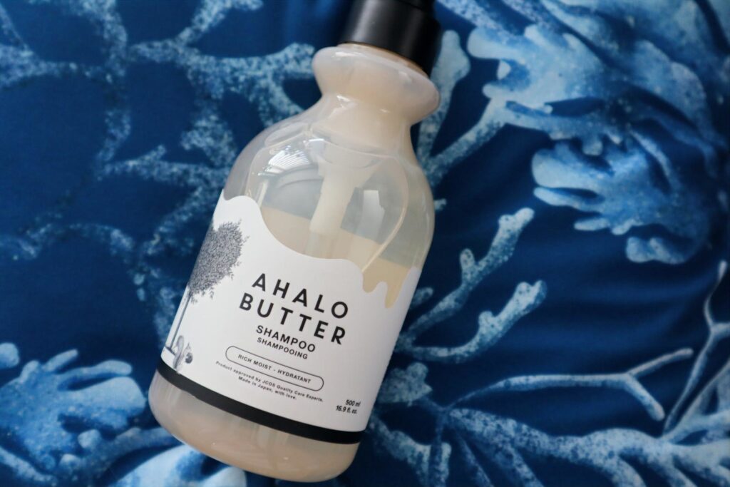 Ahalo Butter Nawilżająco-odżywczy szampon do włosów na niebieskim tle