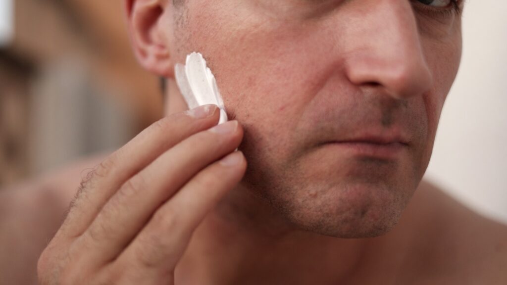 Mężczyzna nakłada na twarz piankę do golenia