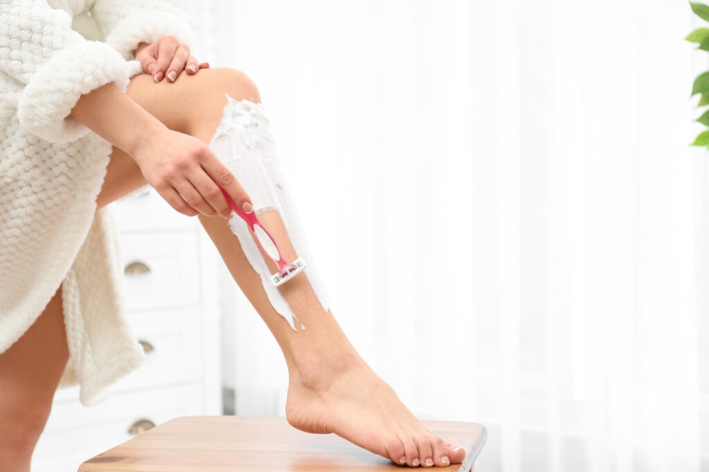 Kobieta goli nogi maszynką jednorazową