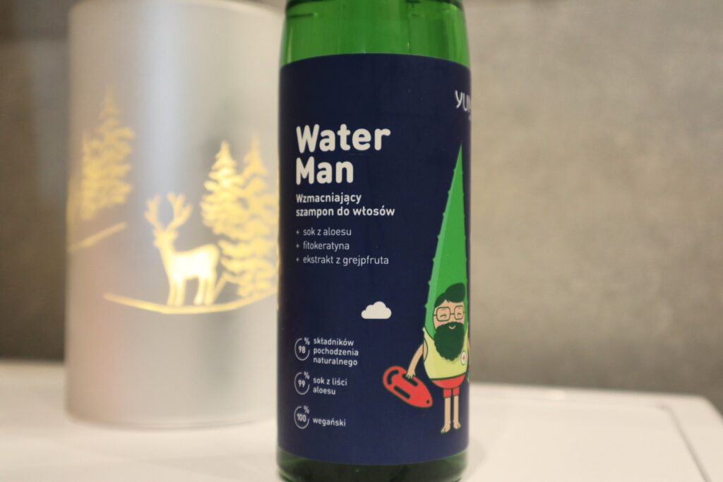 Szampon wzmacniający dla mężczyzn Yumi Men Water Man, w tle ozdobna lampka