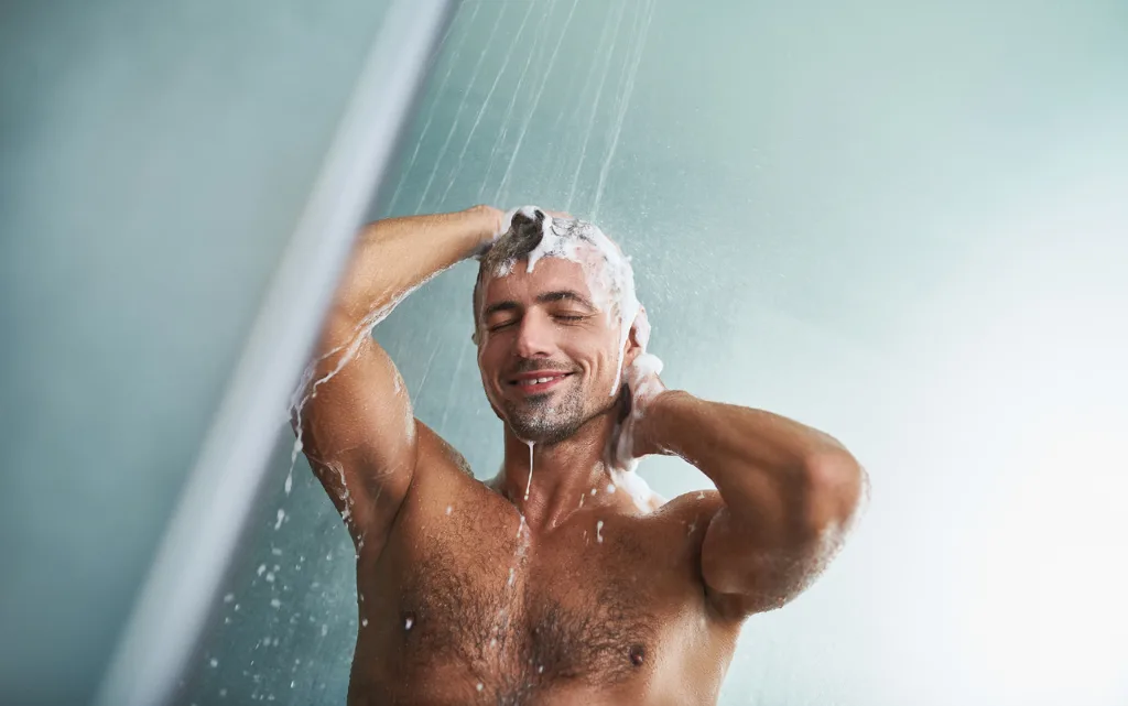 Mężczyzna podczas aplikacji szamponu przeciw wypadaniu włosów