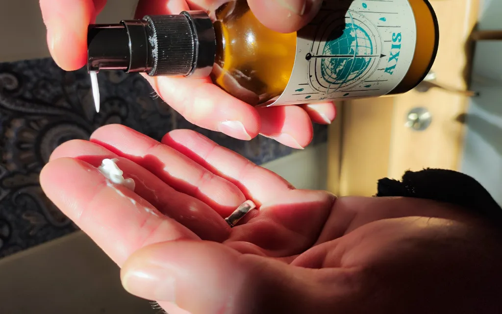 Aplikacja balsamu By Elementum Axis na męskiej dłoni