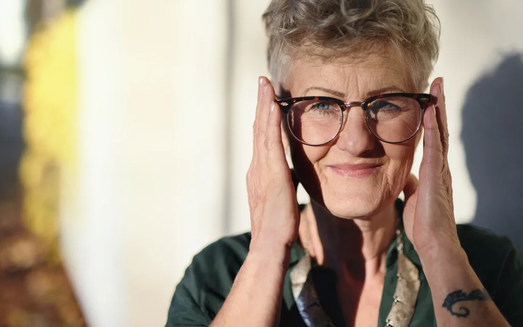 Starsza kobieta ostrzyżona w stylu pixie cut, z falowanymi włosami