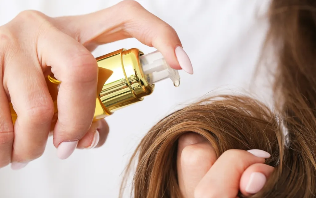 Panna młoda nakłada na końcówki włosów olejek ochronny przeciw puszeniu