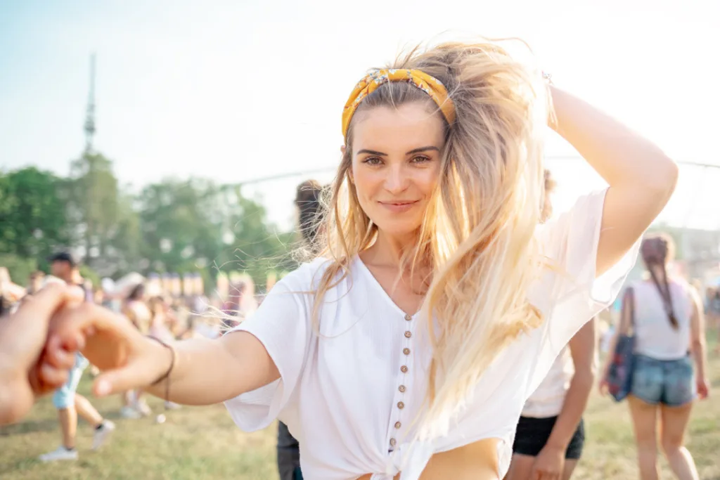 Młoda blondynka z długimi włosami na festiwalu muzycznym w lecie