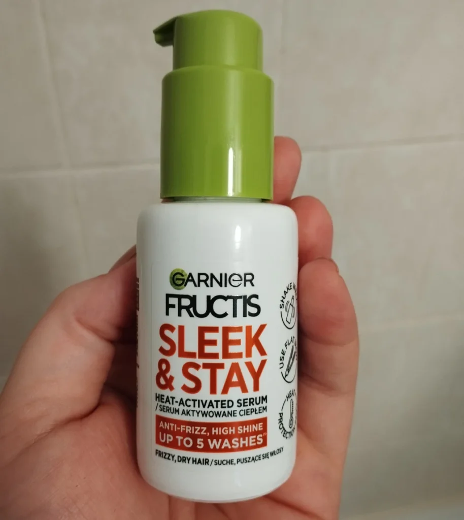 Garnier Fructis Keratin Sleek & Stay serum na puszące się włosy trzymane w kobiecej dłoni