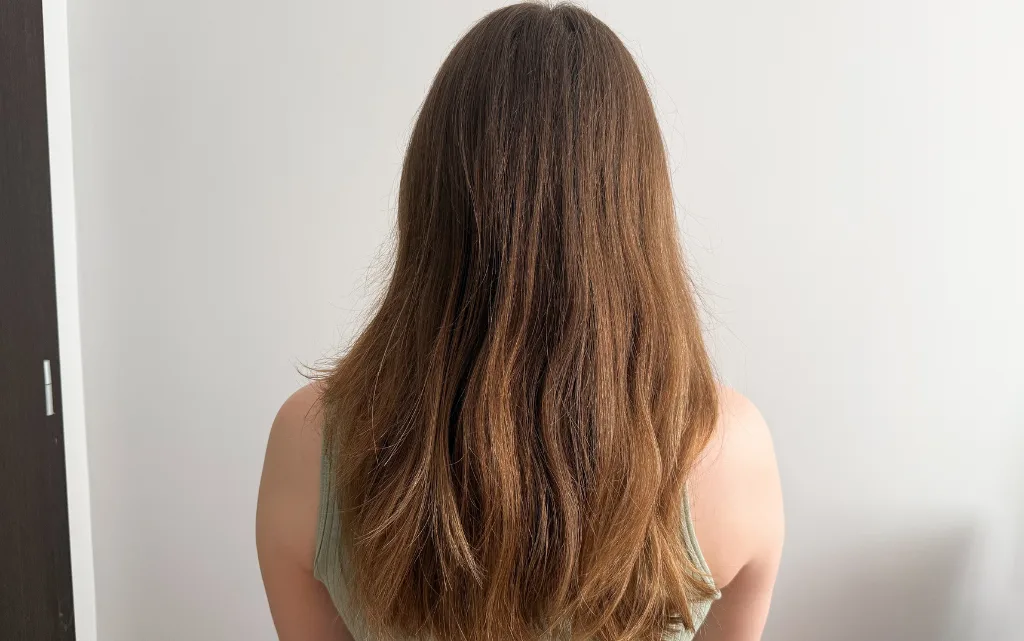 Kobieta odwrócona tyłem po umyciu głowy szamponem naturalnym NEBOA Glossy Hair