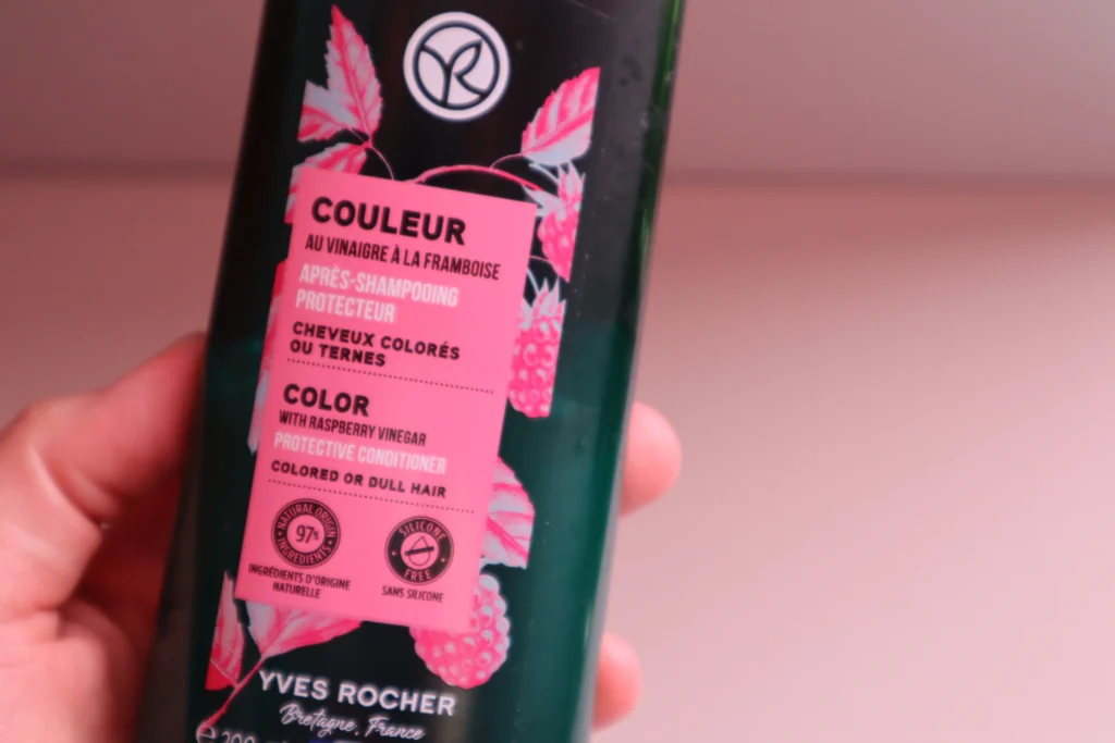 Yves Rocher odżywka chroniąca kolor włosów farbowanych z octem malinowym w kobiecej dłoni