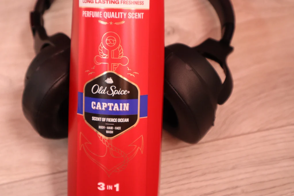 Old Spice Captain żel pod prysznic dla mężczyzn 3w1 na tle bezprzewodowych słuchawek