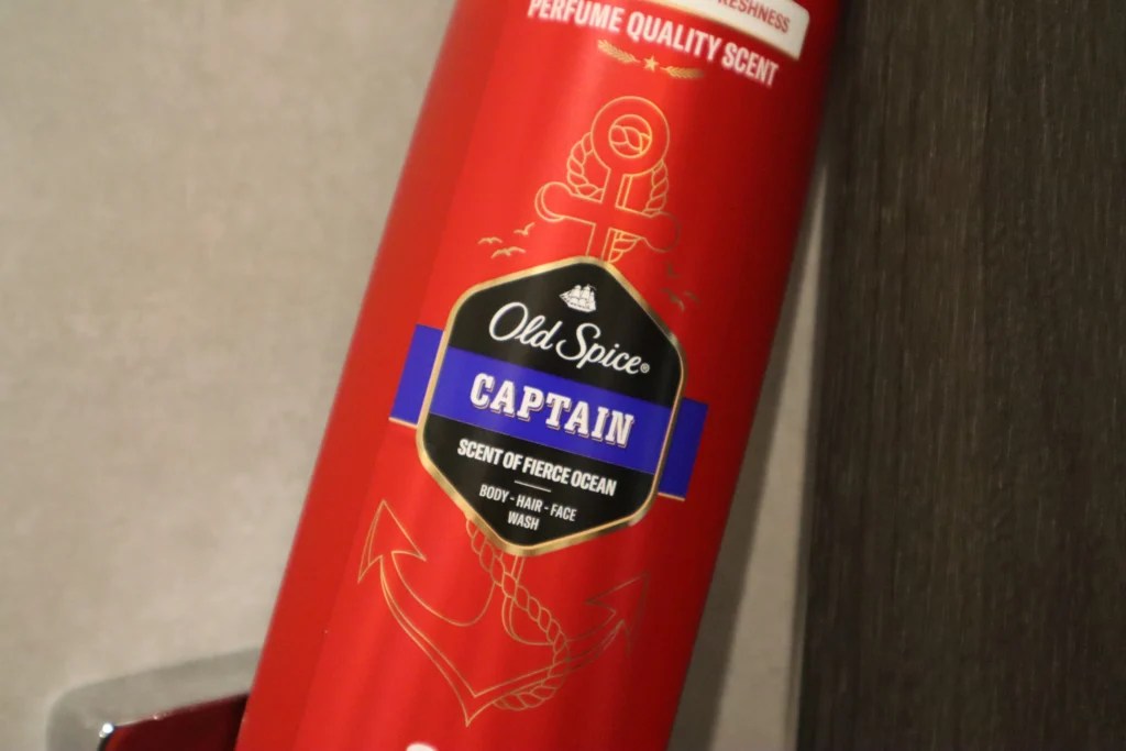 Old Spice Captain żel pod prysznic dla mężczyzn 3w1 oparty o framugę drzwi w łazience