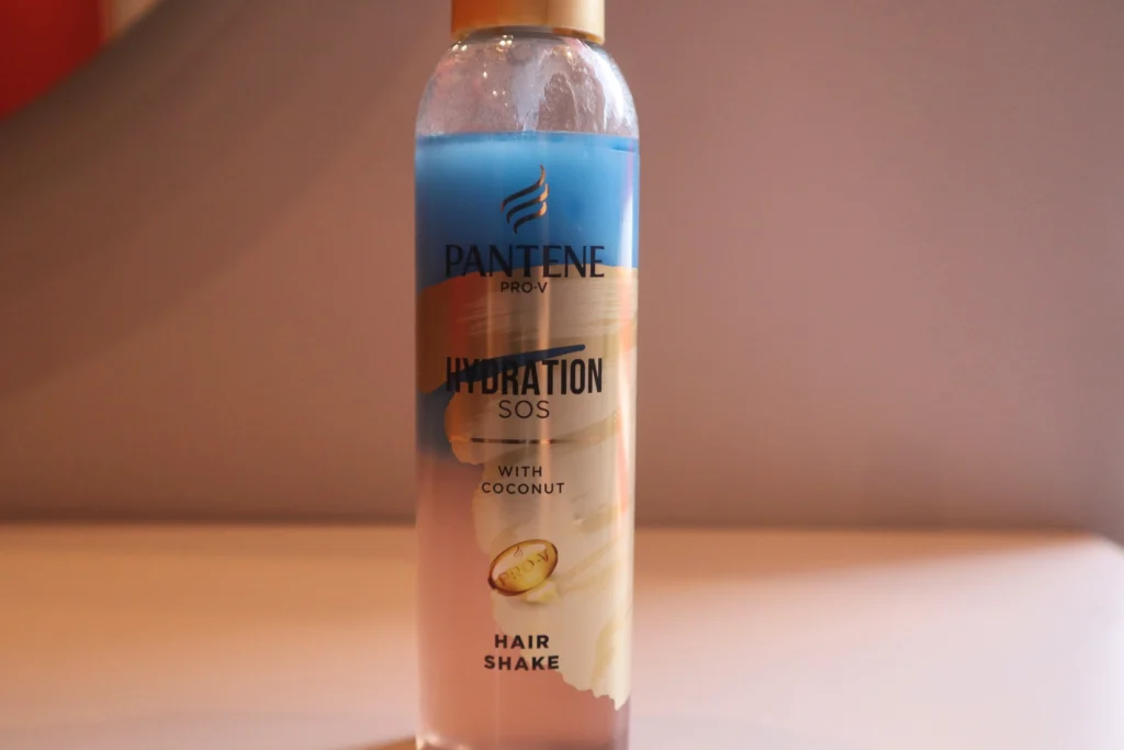 Odżywka w sprayu bez spłukiwania Pantene Pro-V Hydration SOS na tle beżowej ściany