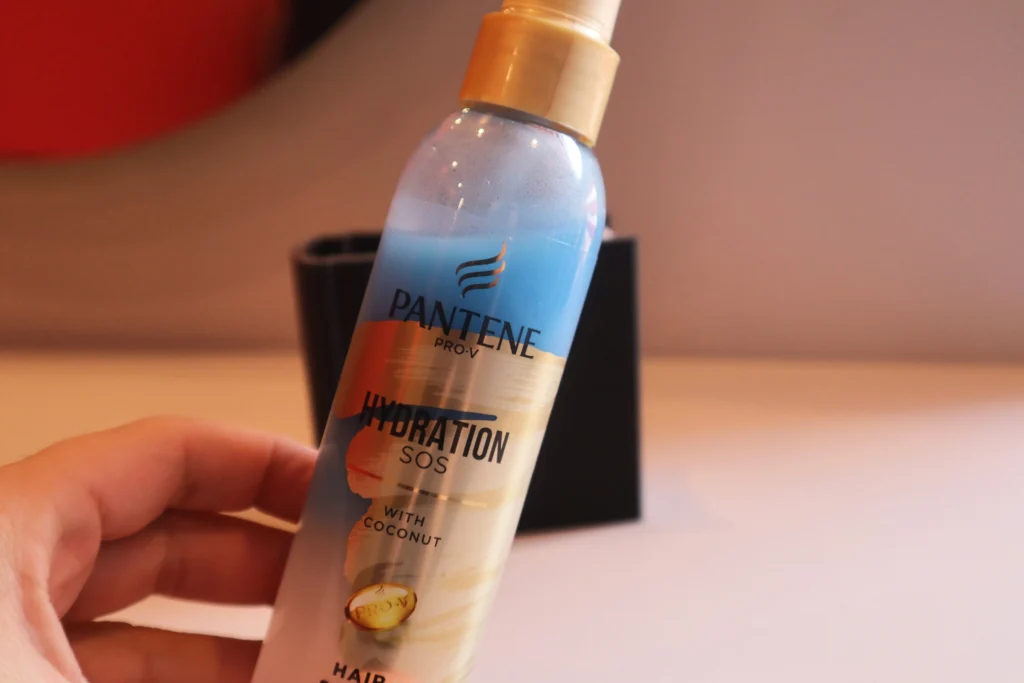 Odżywka w sprayu bez spłukiwania Pantene Pro-V Hydration SOS trzymana w kobiecej dłoni