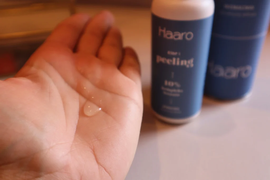 Haaro Peeling do skóry głowy - lejąca się konsystencja na dłoni, ujęcie drugie