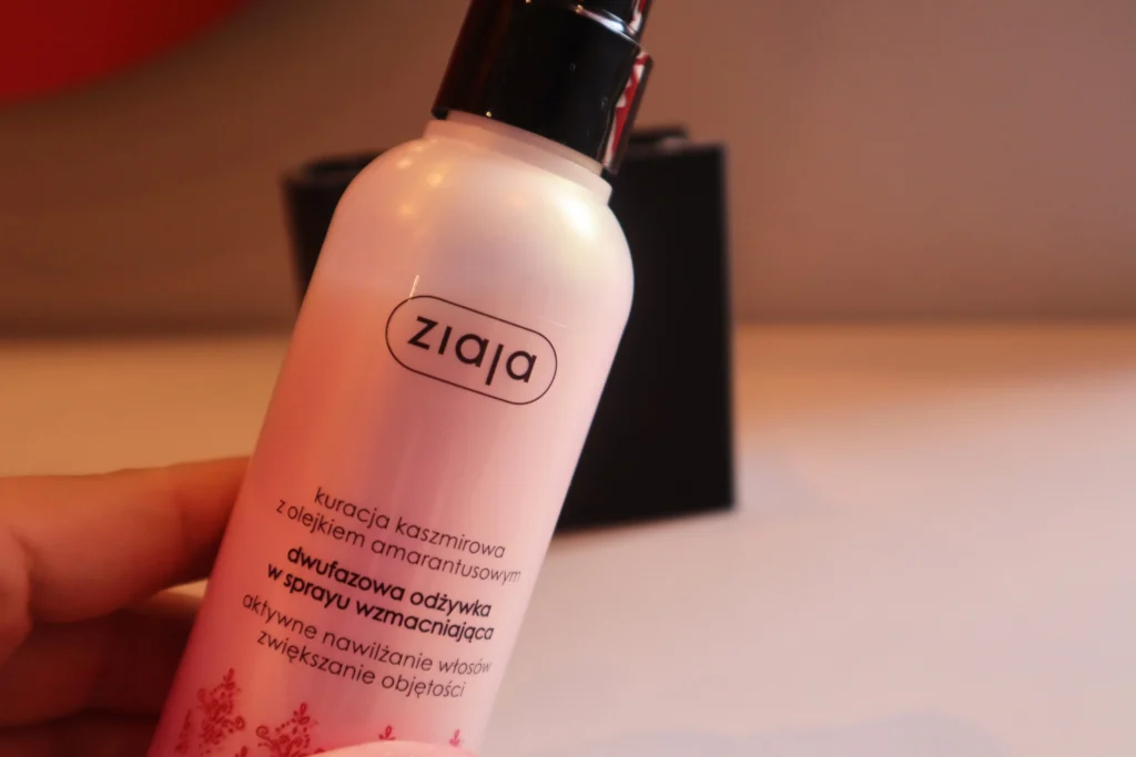 Ziaja Dwufazowa odżywka w spray'u wzmacniająca trzymana w kobiecej dłoni