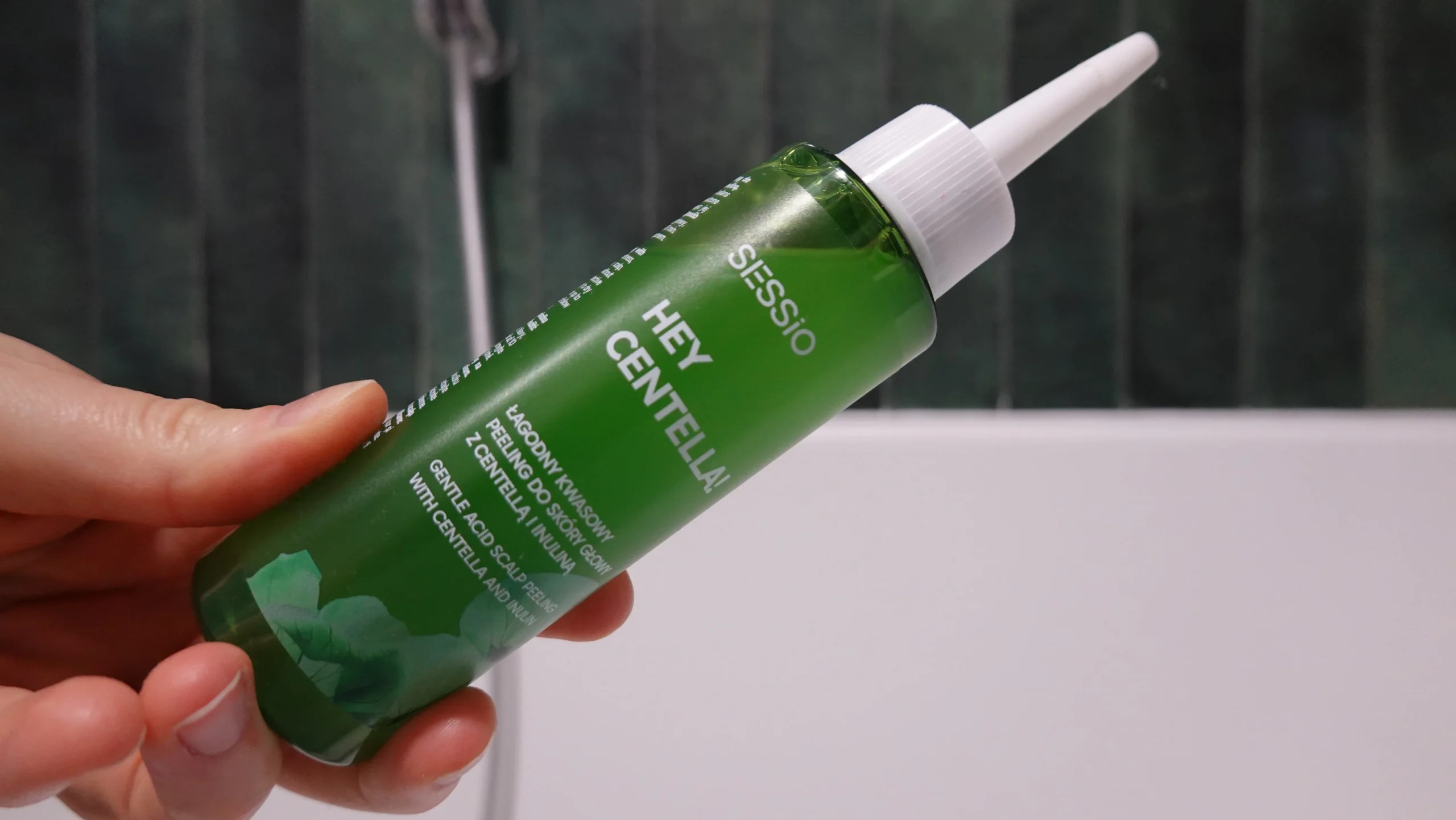Sessio Hey Centella! łagodny kwasowy peeling do skóry głowy z Centellą i Inuliną trzymany w kobiecej dłoni w łazience