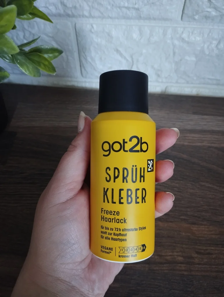Lakier do włosów Got2b Glued Blasting Freeze trzymany w kobiecej dłoni